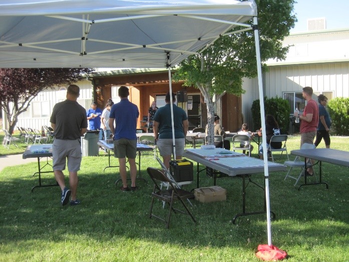 Outdoor workshop with easy up tent, tables, and participants 