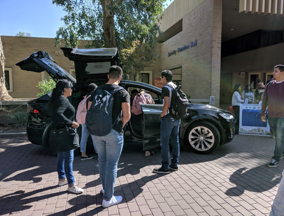 Black Tesla Model X on display while students get in and check out. 