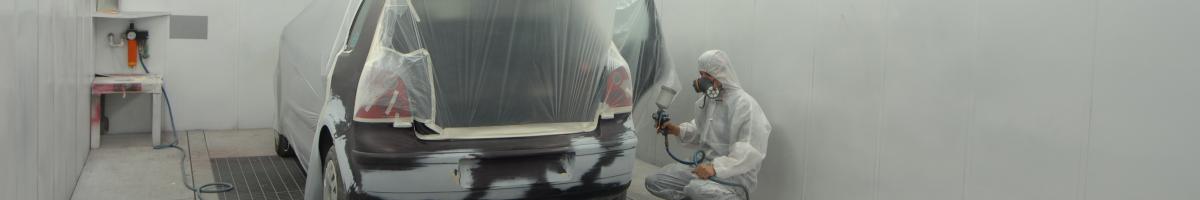man painting car in spray booth