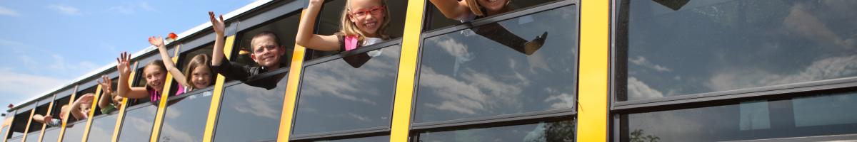 children on school bus waving out windows