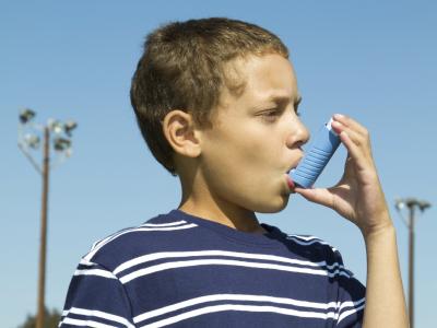 Photograph of a boy using an asthma inhaler