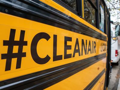 Hashtag #CLEANAIR on closeup of side of electric school bus