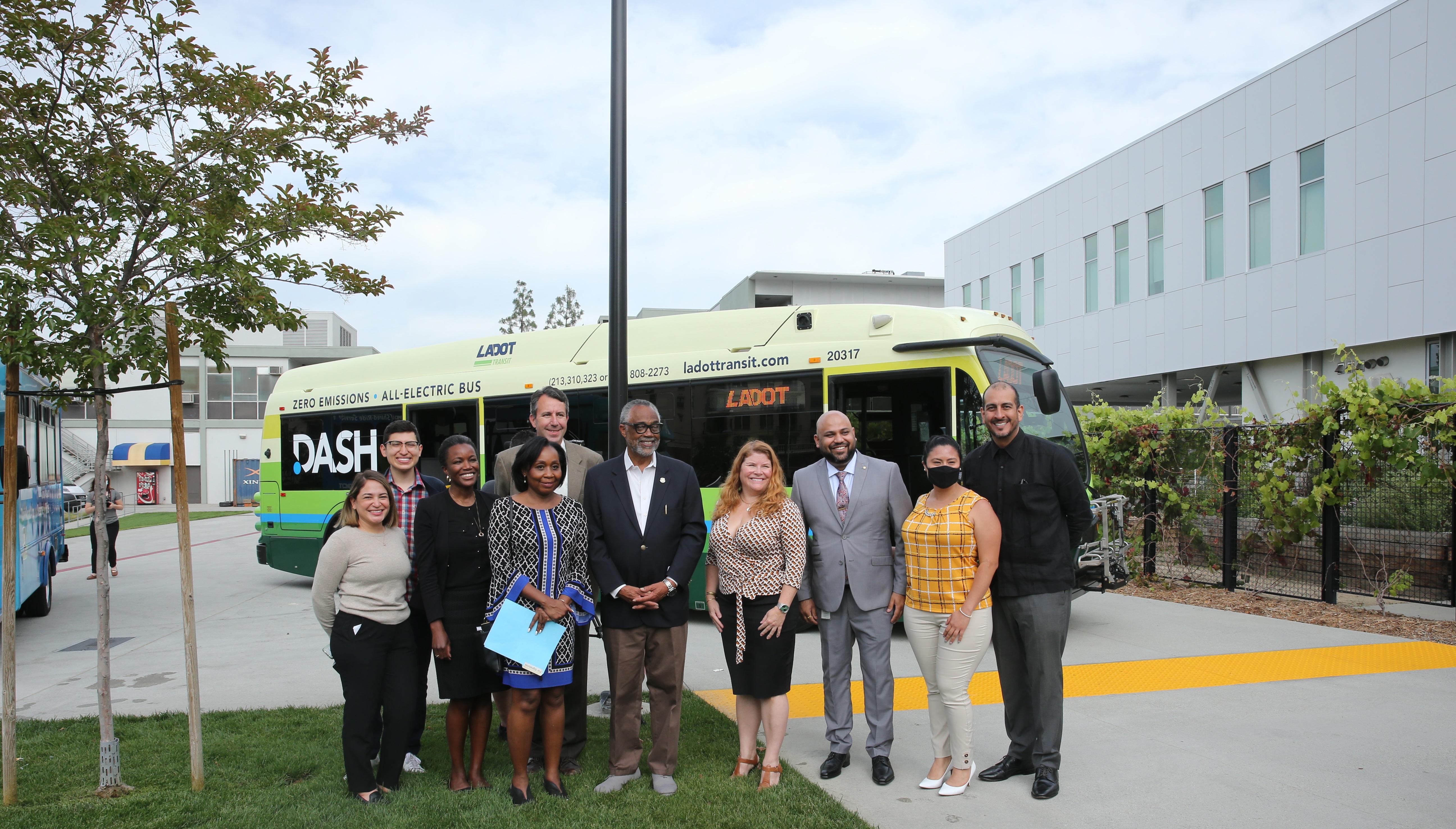 Event participants standing in front of an electric bus