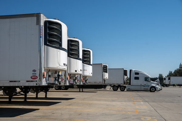 Truck trailers with TRUs sit parked in truck bays