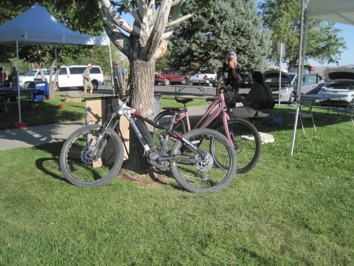 Outdoor demonstration event of EV bikes. EV Bikes leaning up against a true.