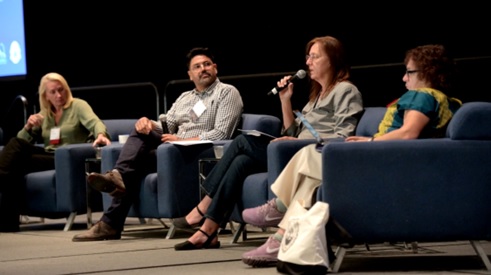 A CMEA panel of people sitting on chairs.