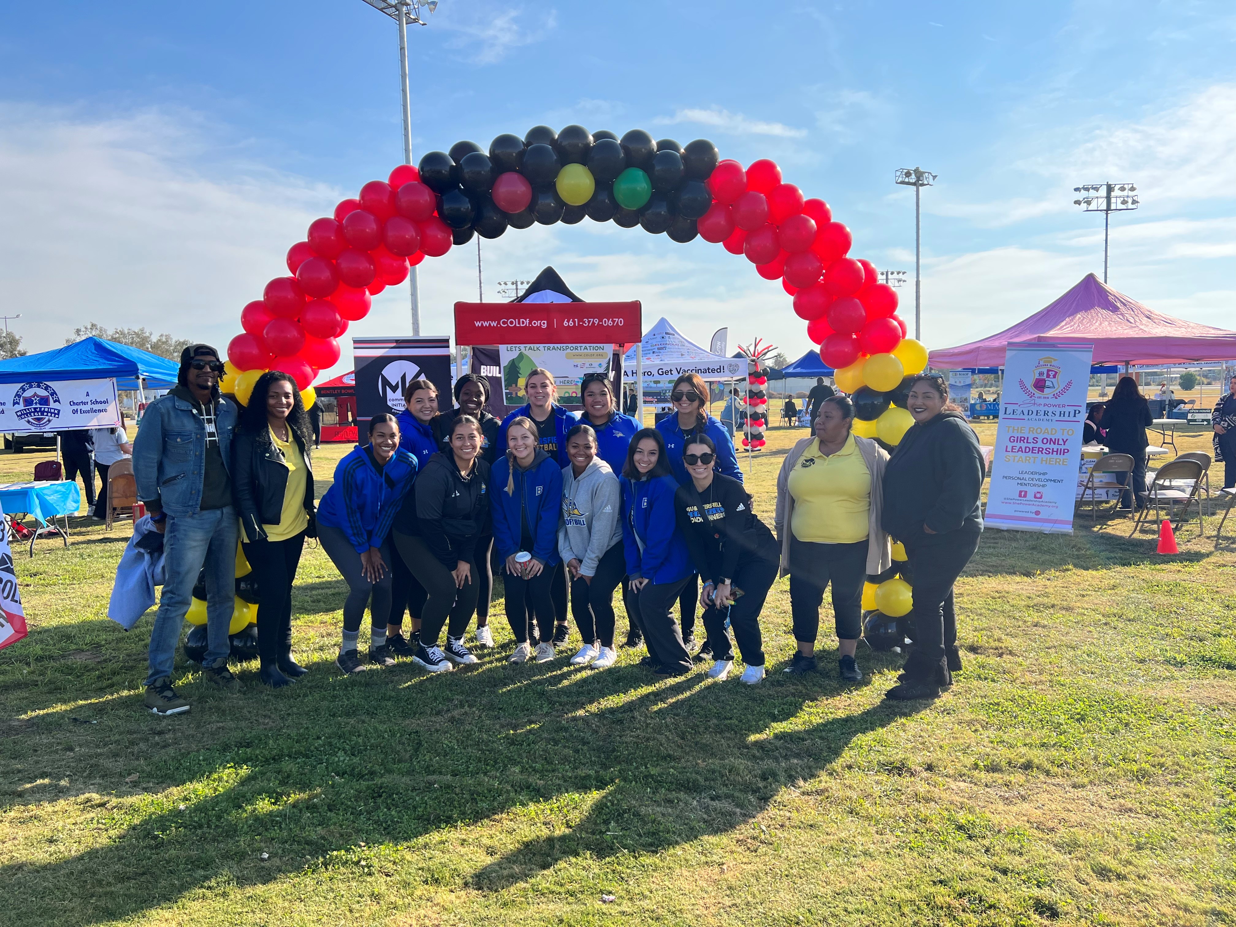 Project team and community residents under balloon arch during Transportation Day event