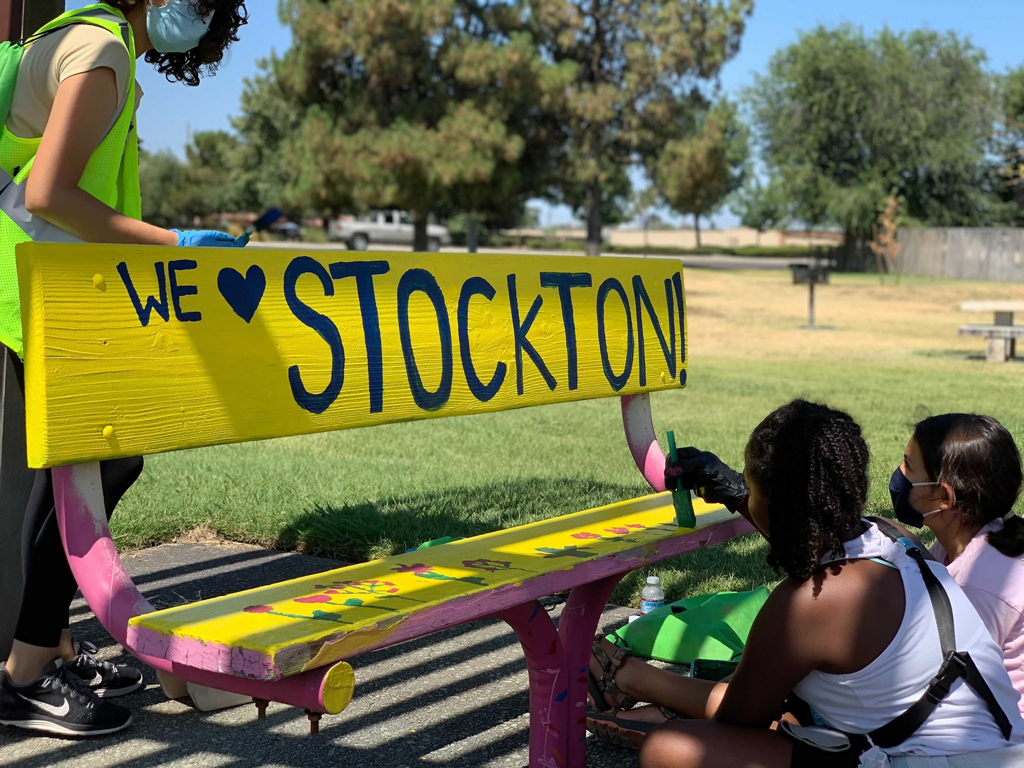 Children Paint "We Love Stockton" on a park bench