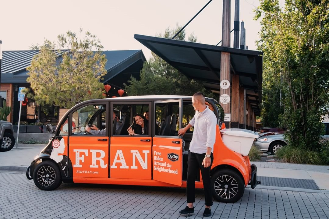 People riding in Free Rides Around the Neighborhood– FRAN electric vehicle