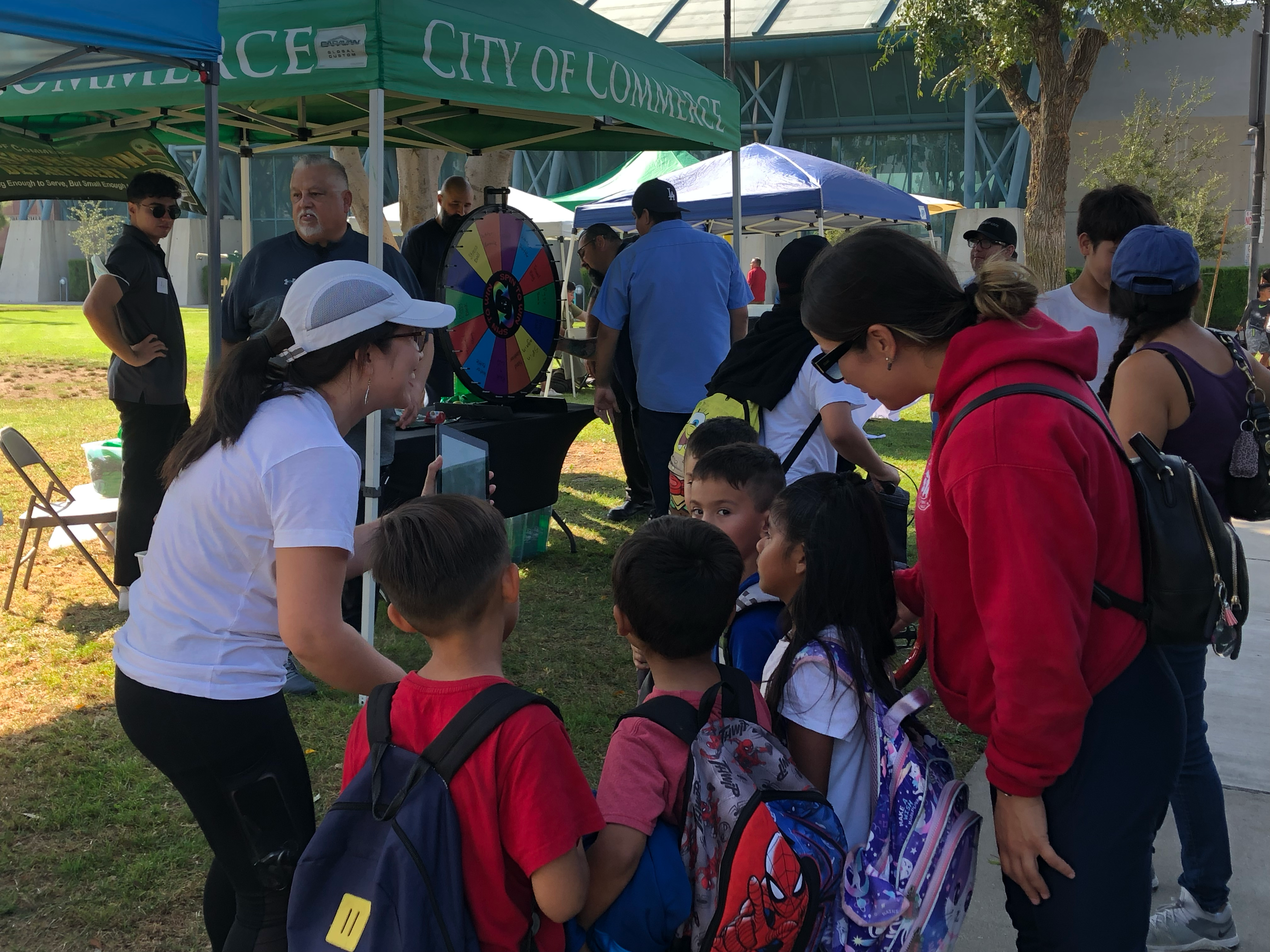 Event participants including children standing in or near project booth