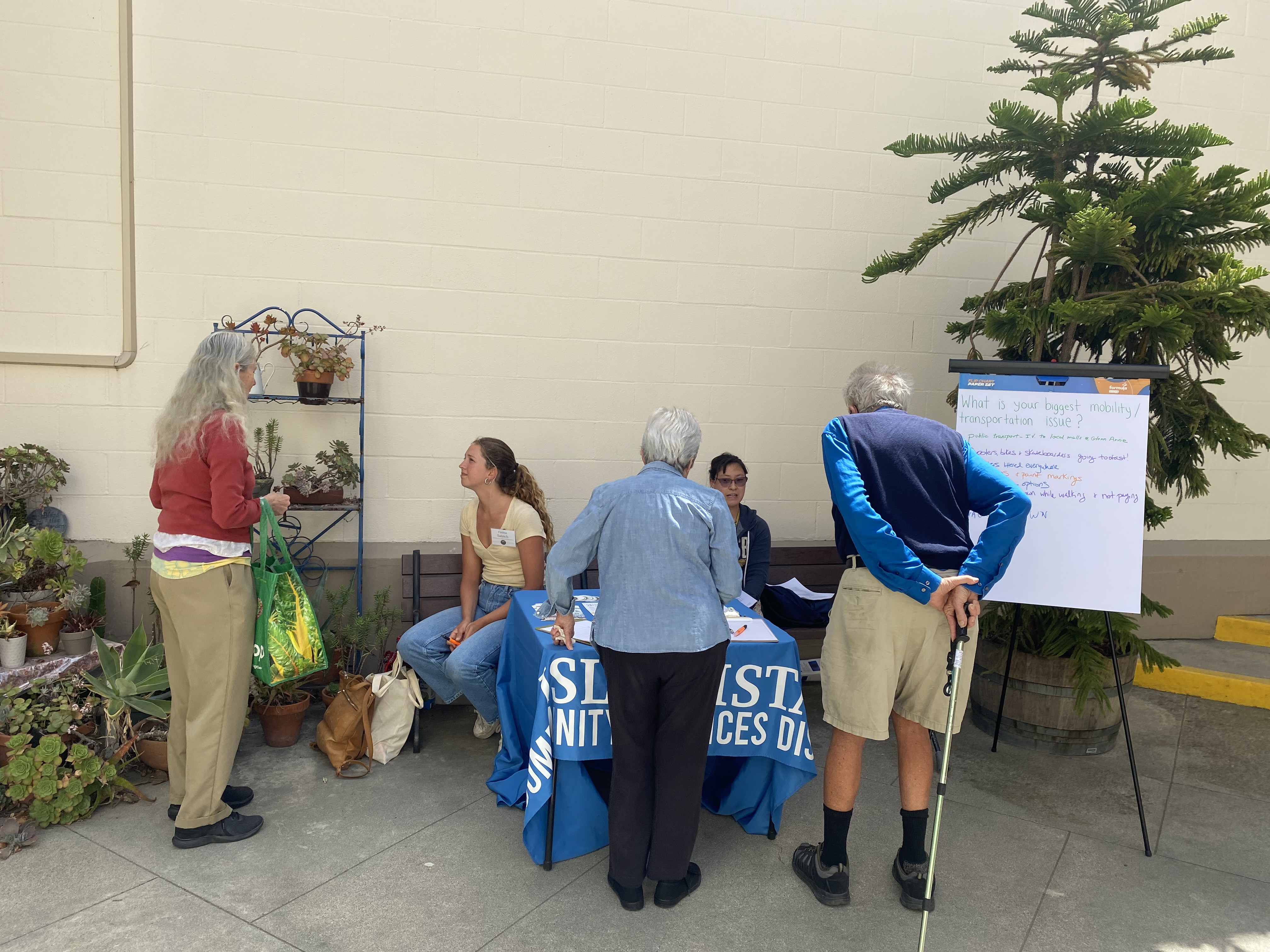 Project team tabling at community event talking to residents