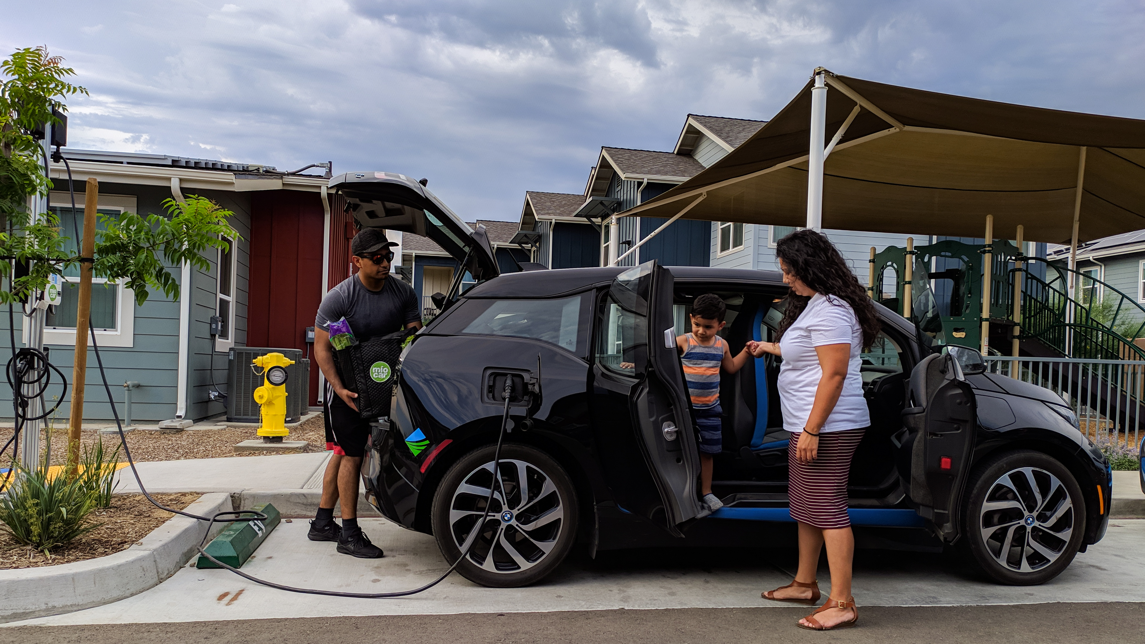 family unloading groceries from an electric vehicle
