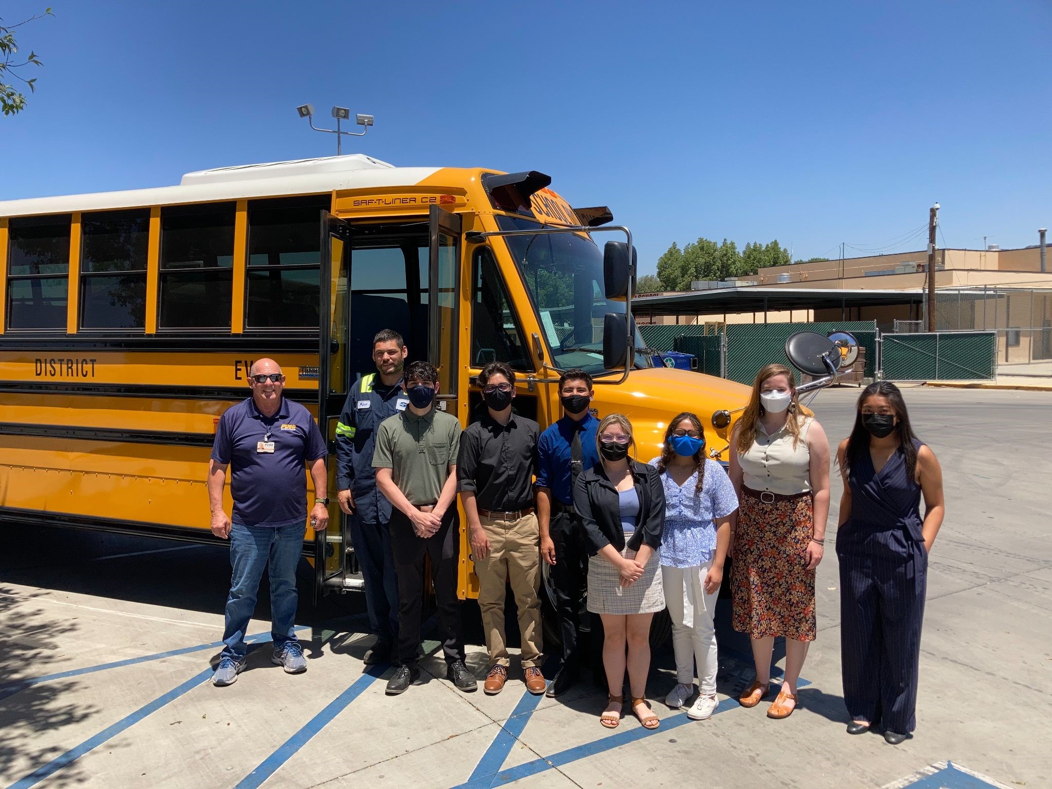 Student interns were the first passengers on the district’s new electric school buses. Student and staff pose in from of bus most wearing COVID masks.