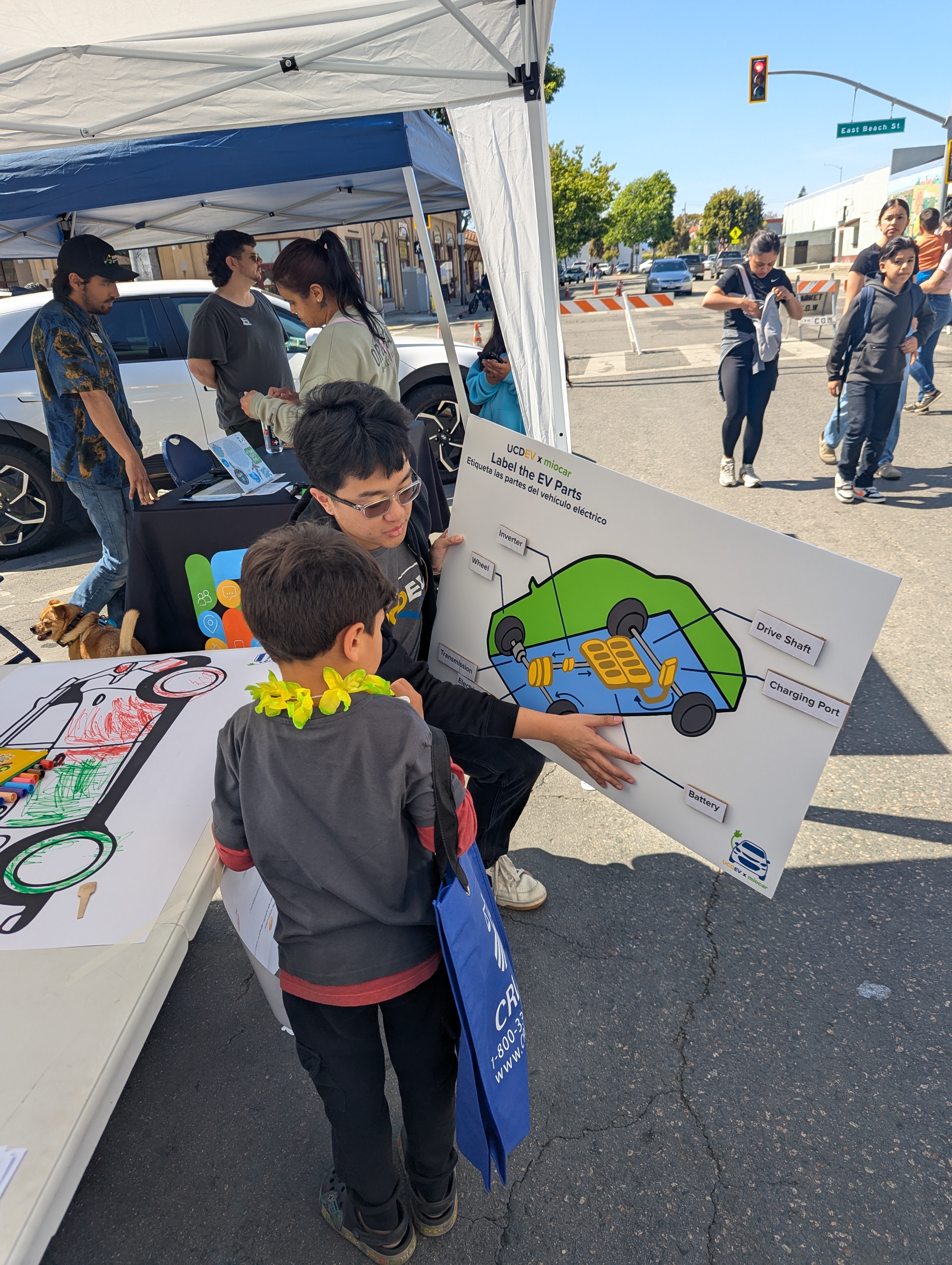 Earth Week of Climate action even with volunteer showing a diagram of EV at UC Davis Electric Vehicle Research Center booth. 