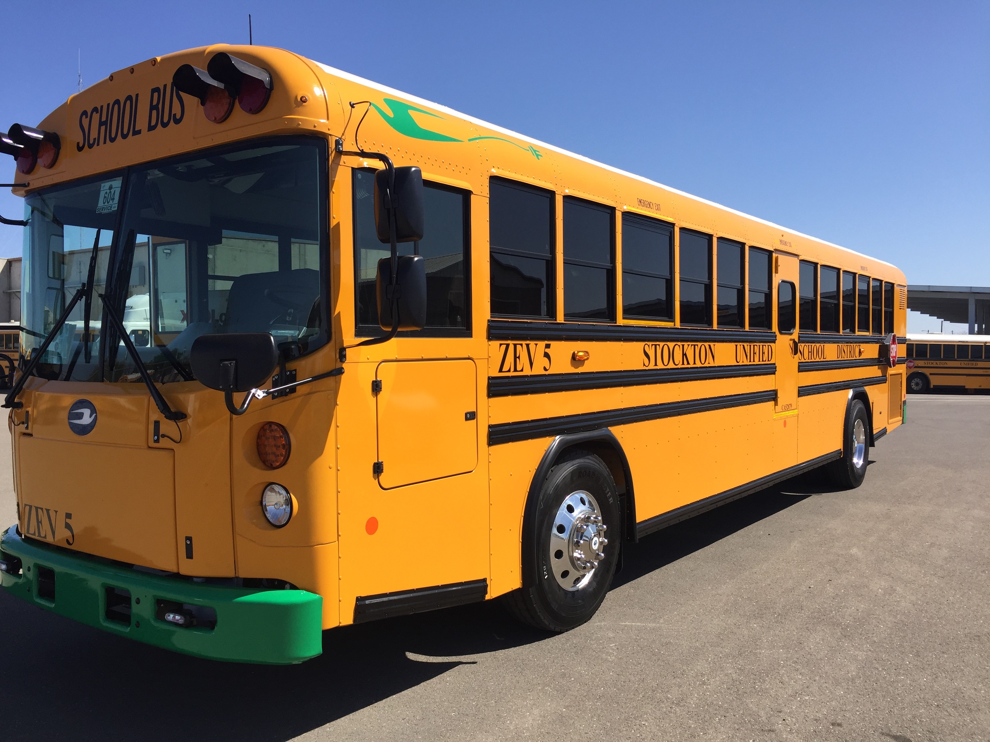 SUSD Angled view of new yellow electric school bus with green bumper