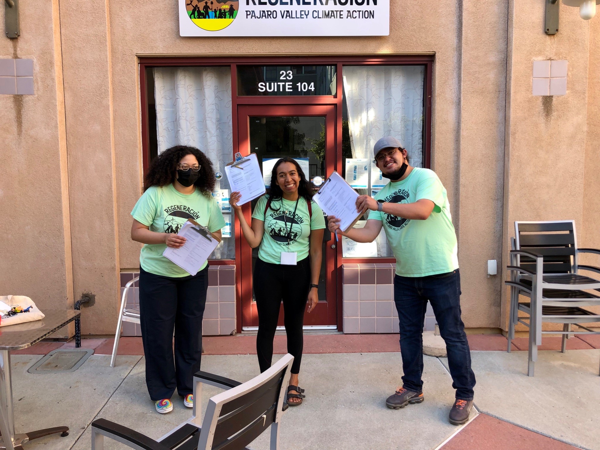 Social Good Fund project Regeneration survey team after final day of canvassing. The 3 pictured are holding clipboards, wearing green Regeneration t-shirts.