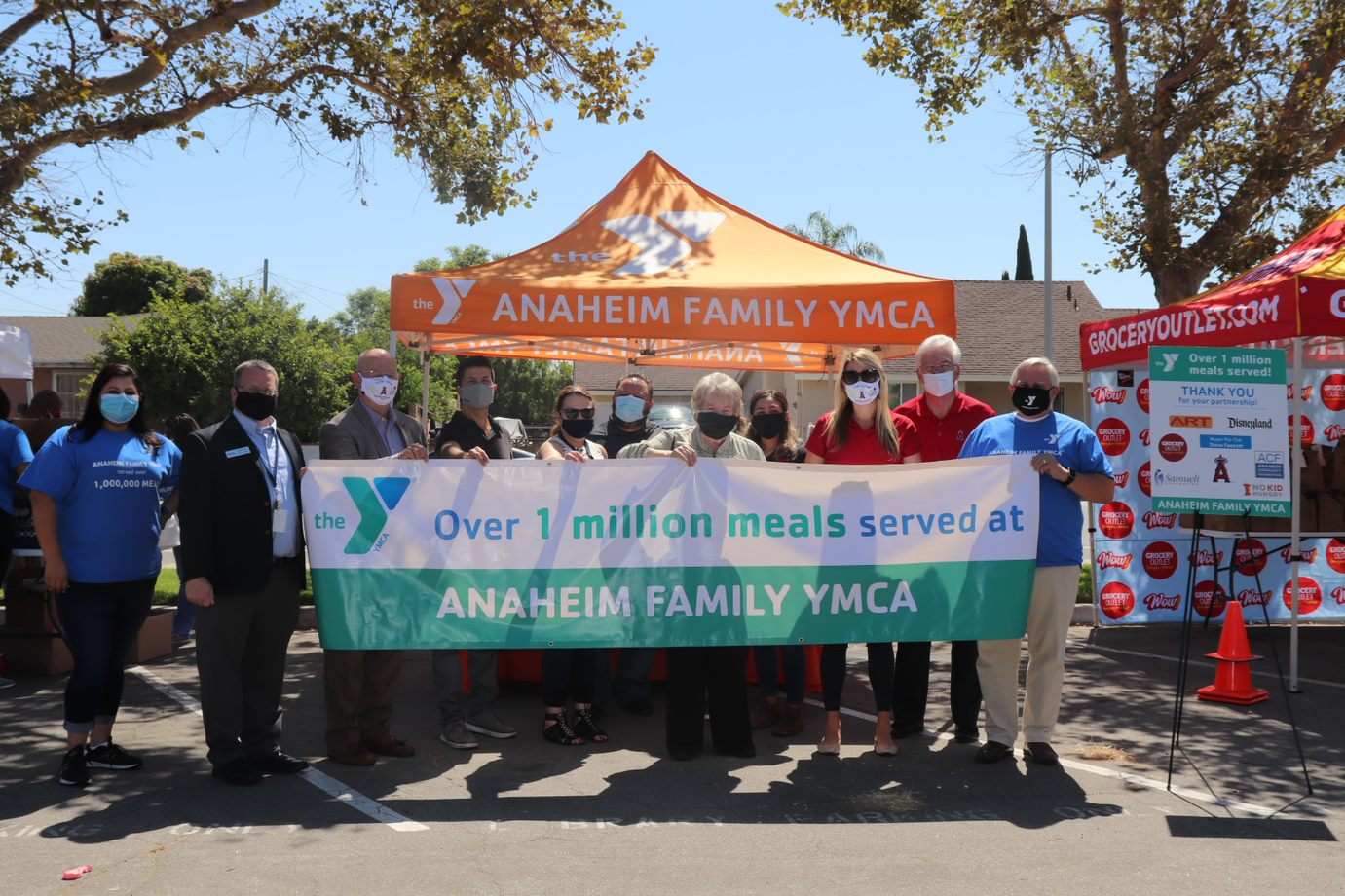 YMCA Community Engagement Event Participants holding banner stating over 1 million meals served