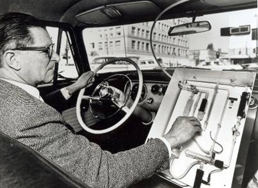 Dr. Arie Haagen-Smit driving a 1960s era vehicle equip with air monitoring equipment