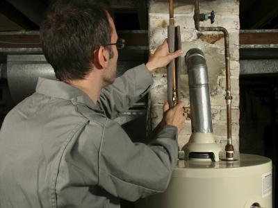 man insulating water heater pipes